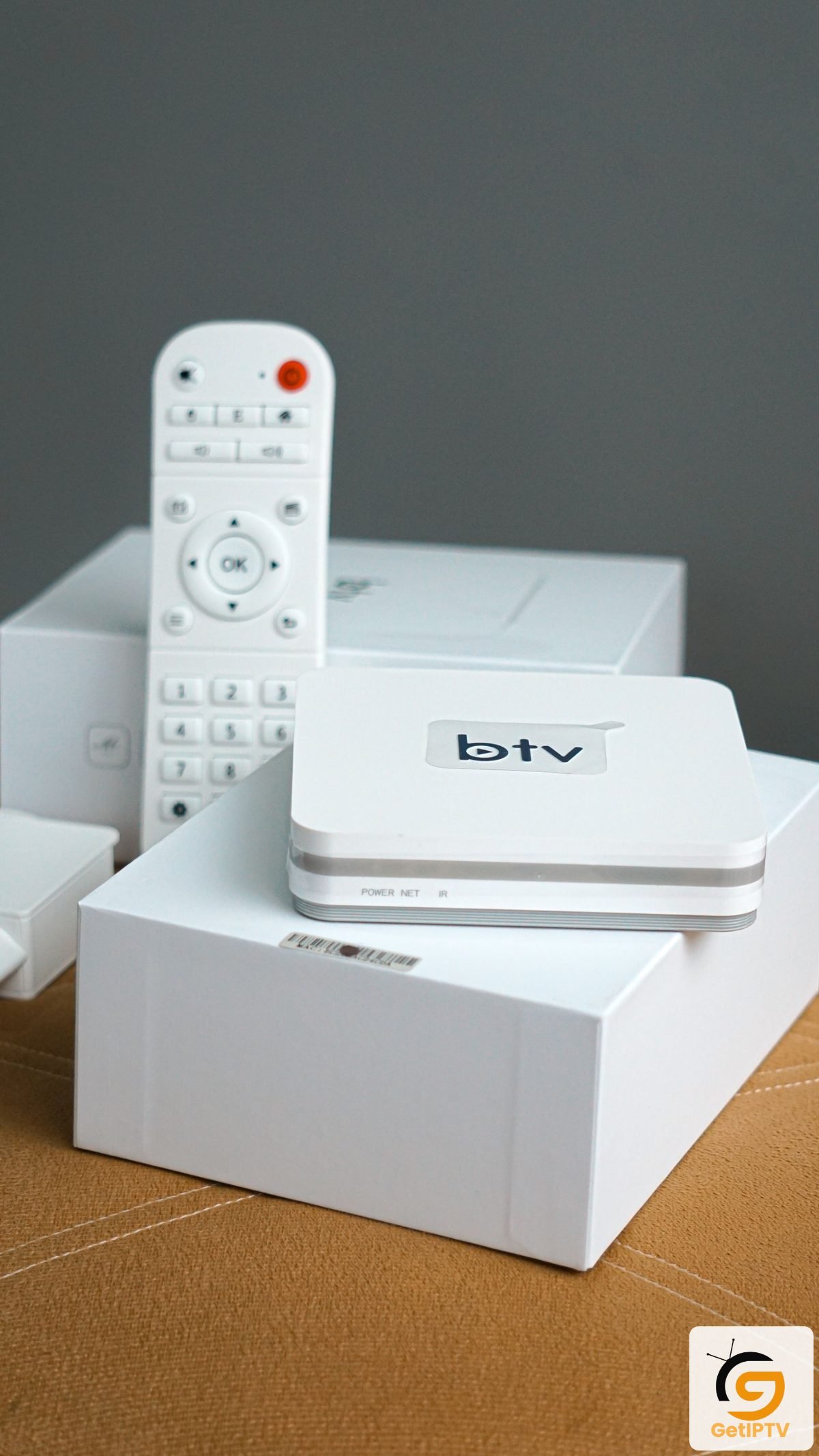 Real photo of smart TV control equipment and remote; GetIPTV logo added