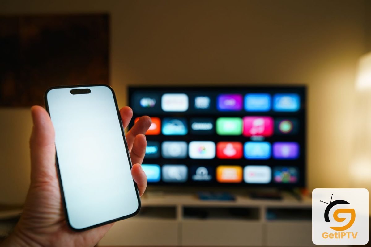 Real photo of a smartphone in front of a smart TV displaying apps; GetIPTV logo added